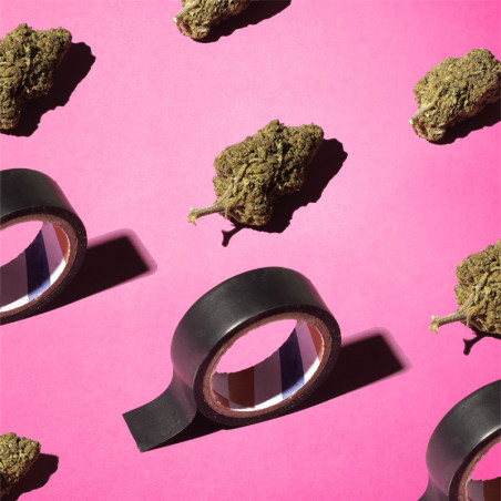 Fleurs de CBD posées sur une surface rose et avec du scotch noir