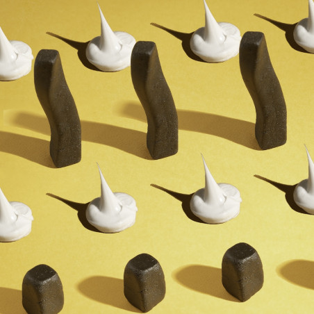 Plusieurs bouts de résine de CBD sur fond jaune, entouré de crème